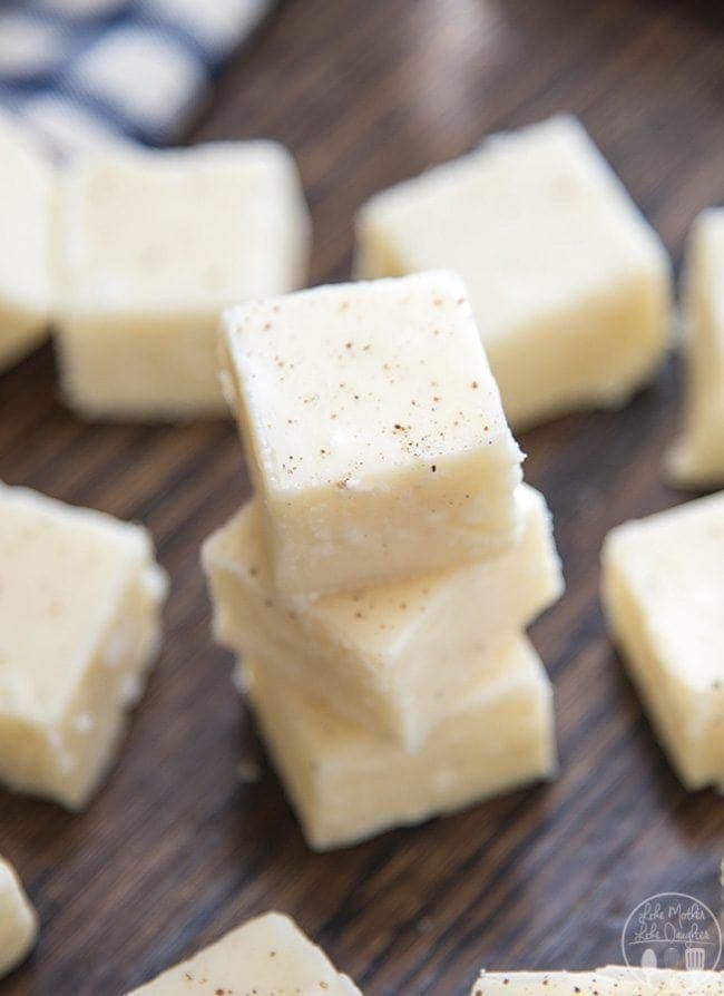A stack of three pieces of eggnog fudge topped with nutmeg. 