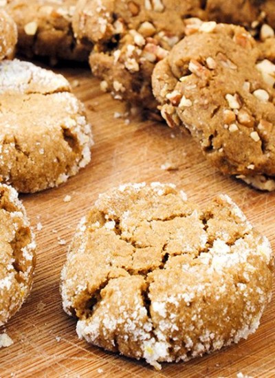 Angled view of orange molasses cookies on a white board.