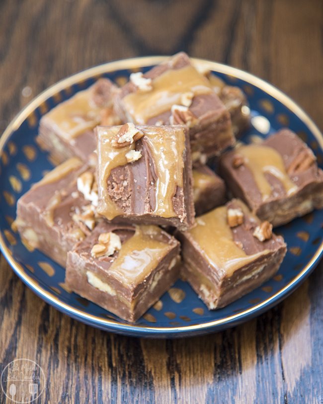 A plate with a pile of chocolate turtle fudge pieces. 