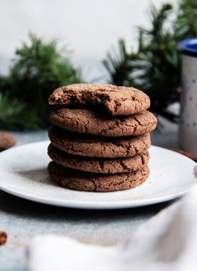 A stack of Mexican hot chocolate snickerdoodles on a plate, and the top cookie has a bite out of it.