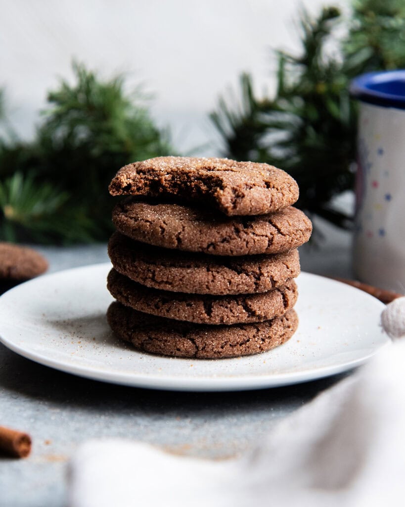 A stack of Mexican hot chocolate snickerdoodles on a plate, and the top cookie has a bite out of it.