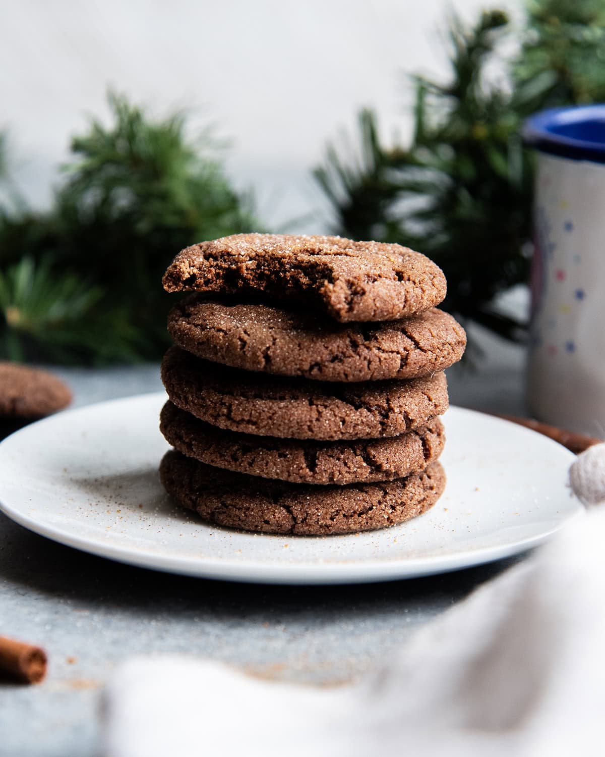 A stack of Mexican hot chocolate snickerdoodles on a plate, and the top cookie has a bite out of it.
