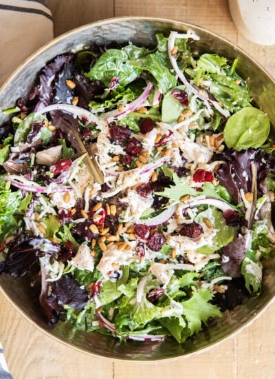 A bowl of a tossed turkey cranberry salad with poppy seed dressing.