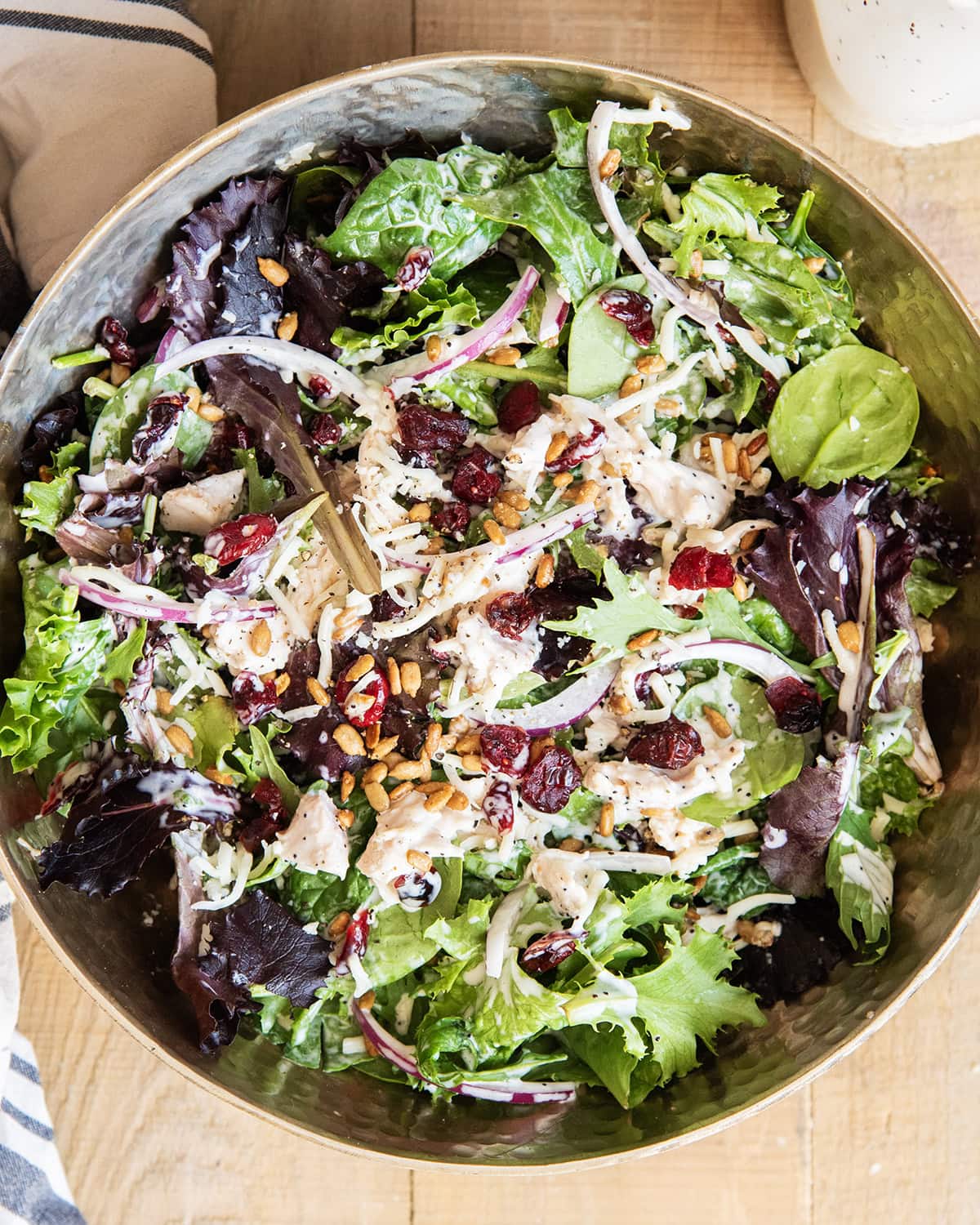 A bowl of a tossed turkey cranberry salad with poppy seed dressing.
