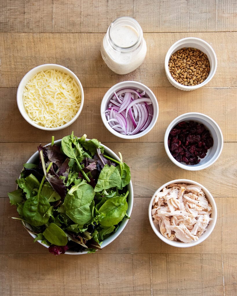 Bowls of the ingredients needed to make turkey cranberry salad with poppy seed dressing.