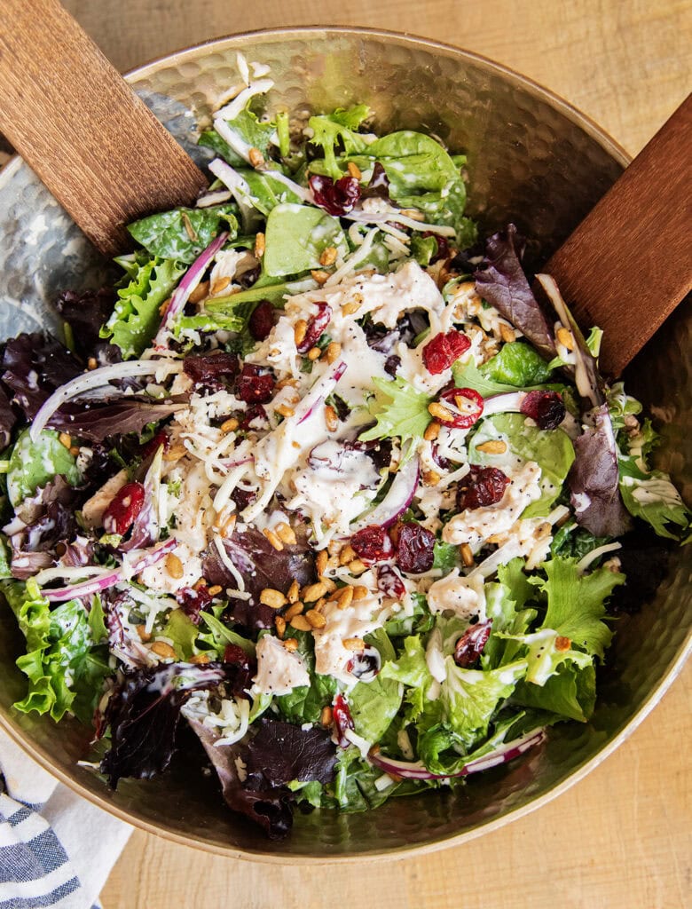 A bowl of a tossed turkey cranberry salad with poppy seed dressing.