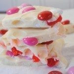 Vanilla cherry Valentine bark with cherries, red white & pink M&Ms, stirred into melted vanilla chips for a pretty creamy Valentine treat for you and your sweetie.