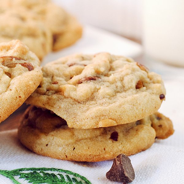 Angled image of butter pecan cookies stacked on each other.
