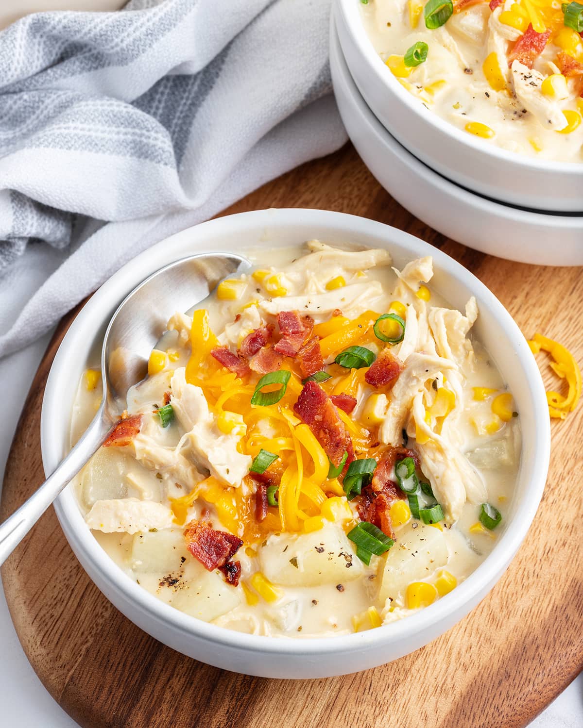 A bowl of cheesy chicken chowder with a spoon in the bowl.