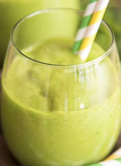 Angled image of a tropical green smoothie in a glass.