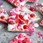 Pieces of Valentine's Day bark candy swirled with reds and pinks and topped with sprinkles and m&ms.