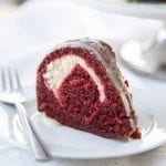 Angled image of a slice of cream cheese stuffed red velvet cake.