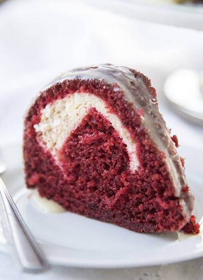 Angled image of a slice of cream cheese stuffed red velvet cake.