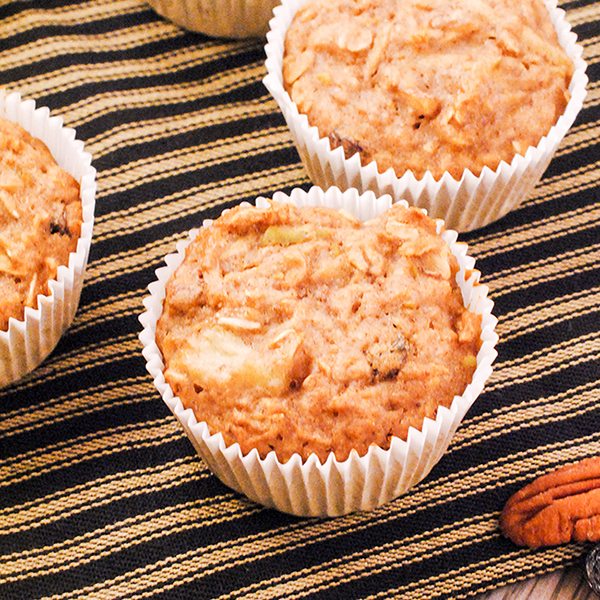 Above image of oatmeal raisin muffins on a textured cloth.