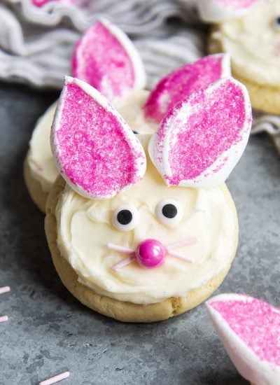 An Easter Bunny Cookie decorated with white frosting, marshmallows, candy eyes, and a pink candy nose.