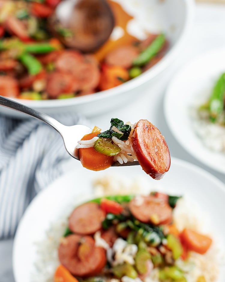 Close up image of a scoop of polska kielbasa stir fry on a fork.
