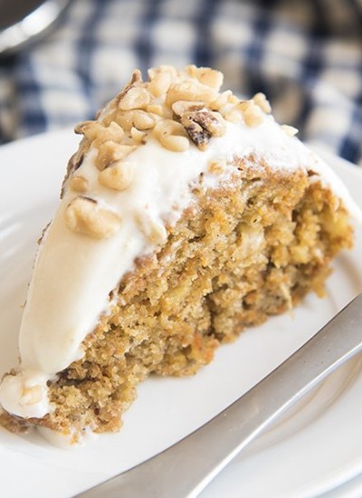 Angled image of a slice of lighter carrot cake on a white plate.