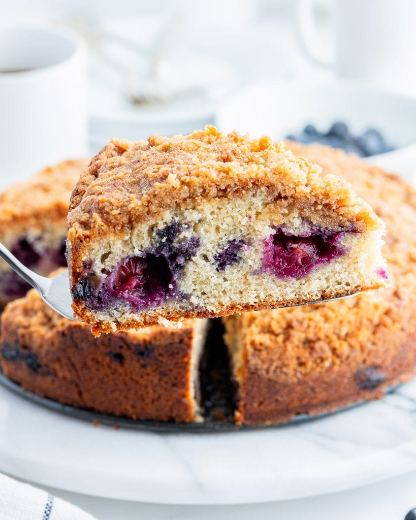 A slice of blueberry coffee cake on a serving spatula.