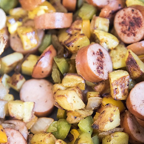 Above image of breakfast hash with eggs, sausage, potatoes, and potatoes.