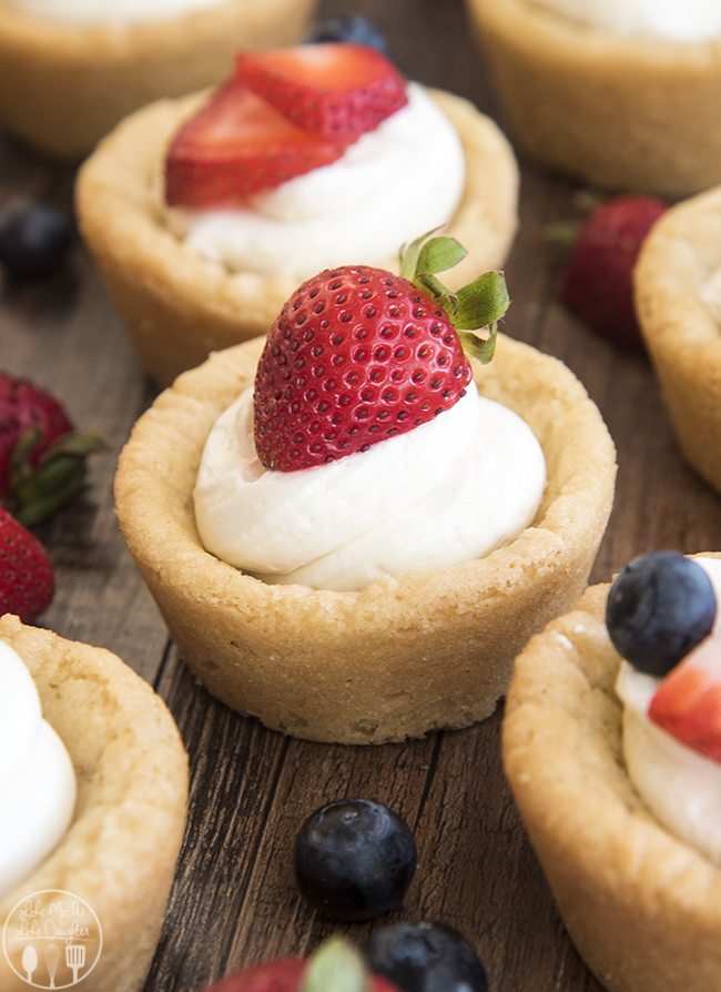 Cheesecake Sugar Cookie Cups - These amazing cookie cups have a sugar cookie for a crust, toppedÂ with a simple no bake cheesecake filling and your favorite fruit. These cookie cups are perfect for an easy yet elegant dessert.