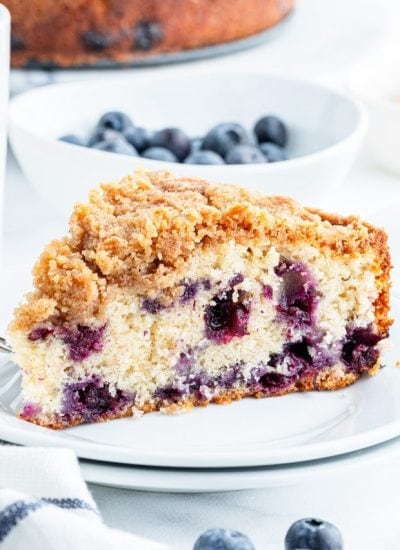 A slice of blueberry coffee cake full of big blueberries, and topped with a streusel crumb topping.