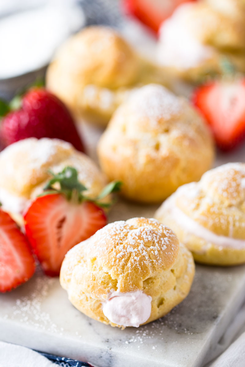 Side image of strawberries and cream puffs.