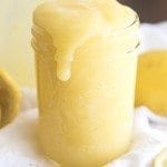 Close up image of lemon curd spilling over the side of a mason jar.