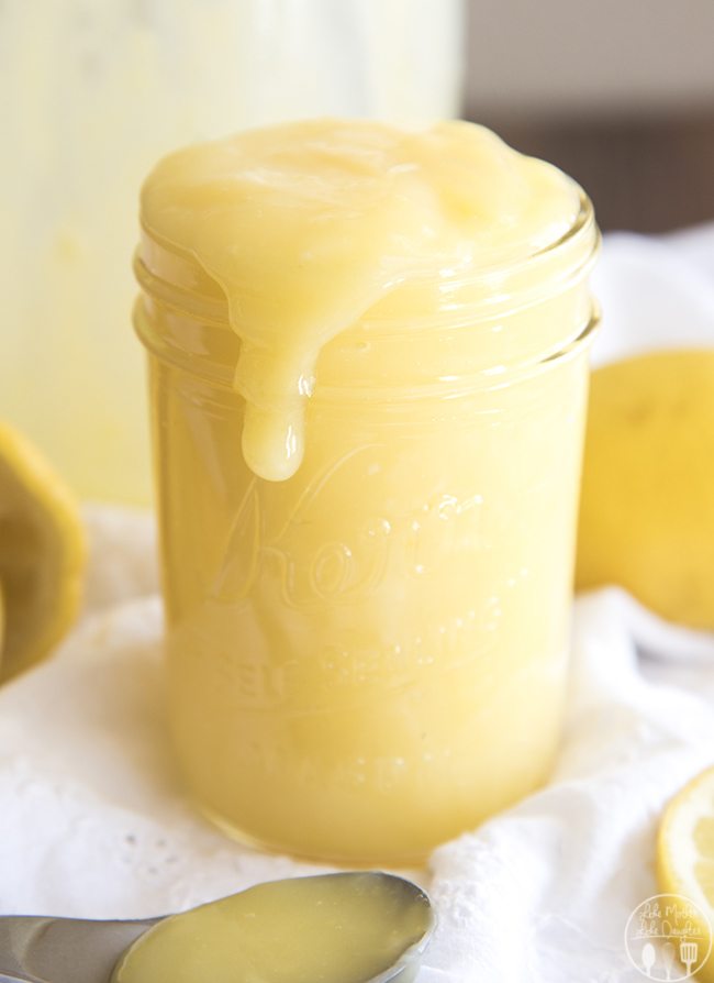 Close up image of lemon curd spilling over the side of a mason jar.