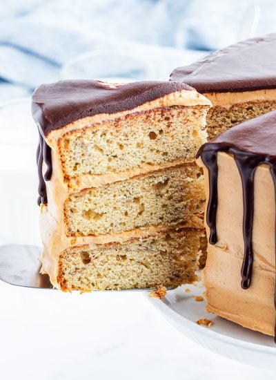 A slice of triple layer banana cake on a spatula being pulled out of the cake.