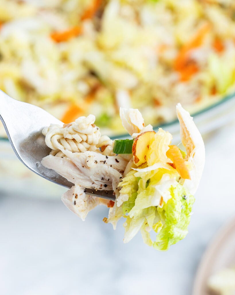 A fork of chicken cabbage and ramen noodle.