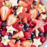 A bowl of red, white, and blue fruit salad with apple, and watermelon stars.