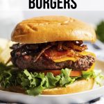 A burger with lettuce, tomato, patty, cheese, brown sugar bacon, and carmelized onions on a bun with a text overlay for pinterest.