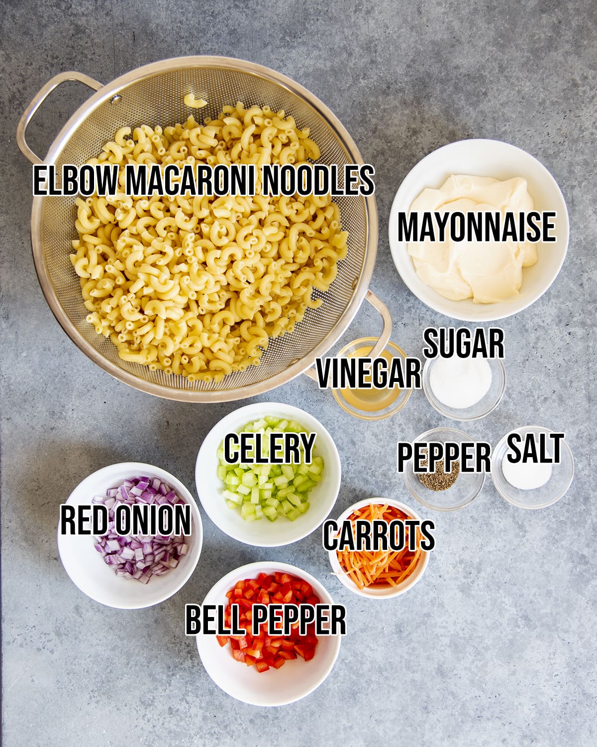 The ingredients needed to make macaroni salad with labels on them.