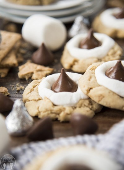 Hershey kiss smores cookies are shown up close on a wood board.