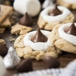 Hershey kiss smores cookies are shown up close on a wood board.