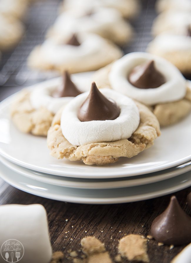 Smores hershey kiss cookies are shown up close on three white plates.