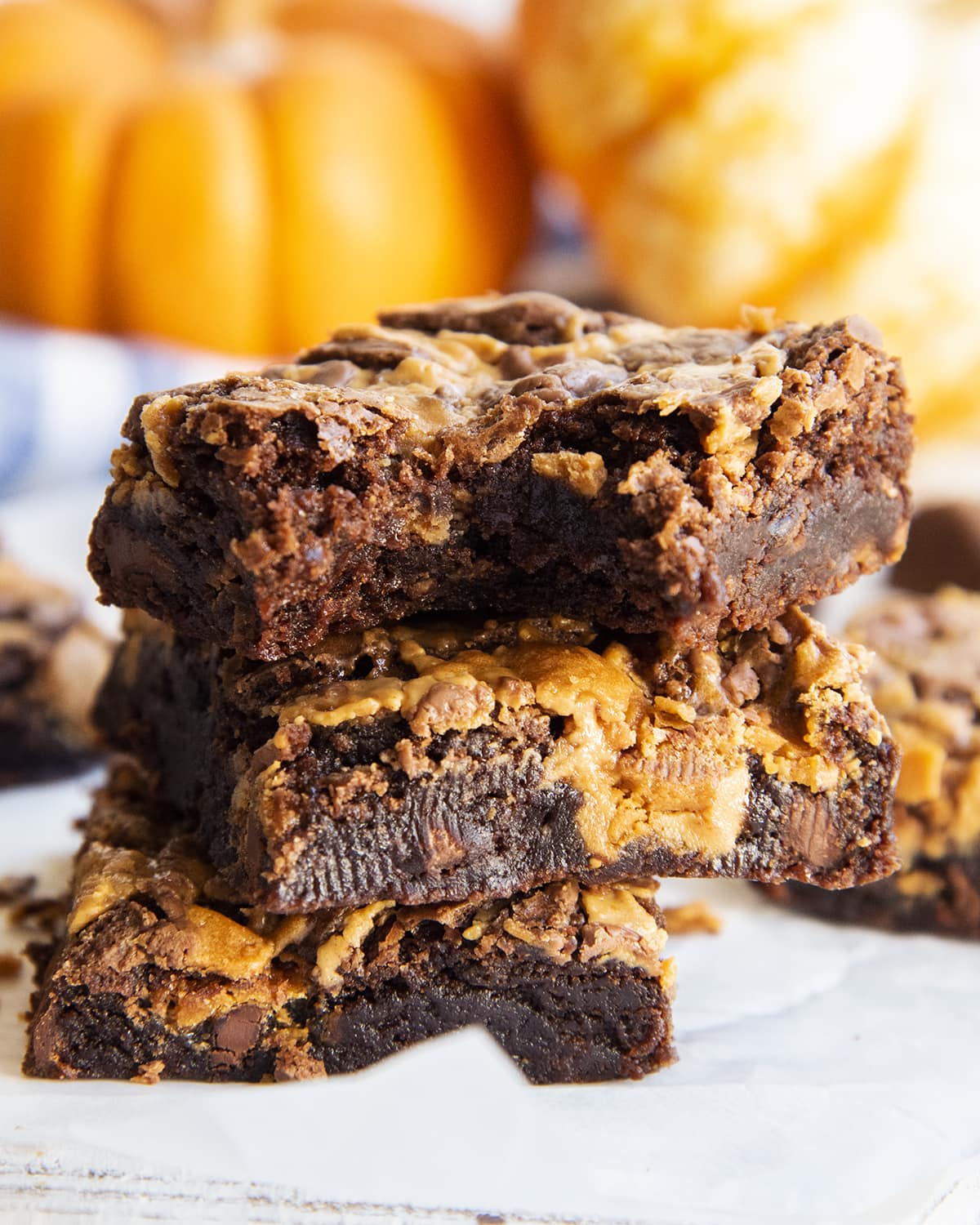 A stack of three Butterfinger brownies, and the top brownie has a bite out of it.
