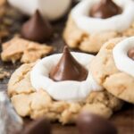 Hershey kiss smores cookies are shown up close on a wood board.