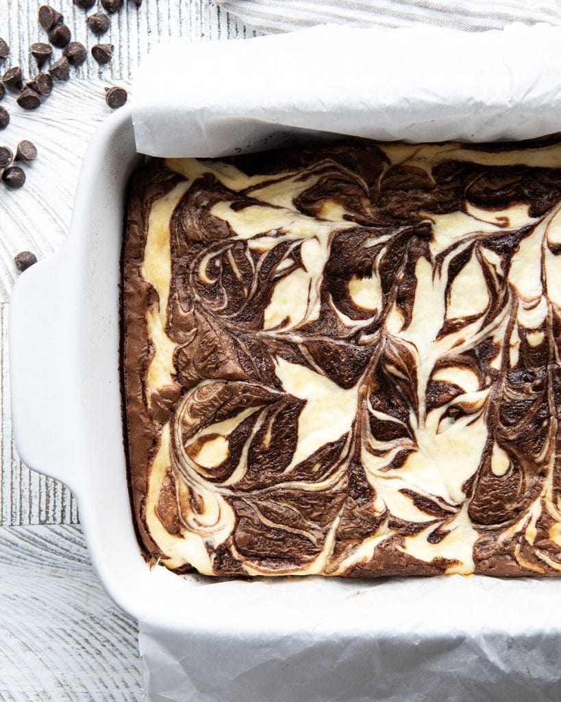 A pan of cream cheese swirled brownies from above, with cheesecake and brownie swirled together.