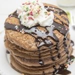 Above image of brownie batter pancakes with whipped cream and drizzle on top.