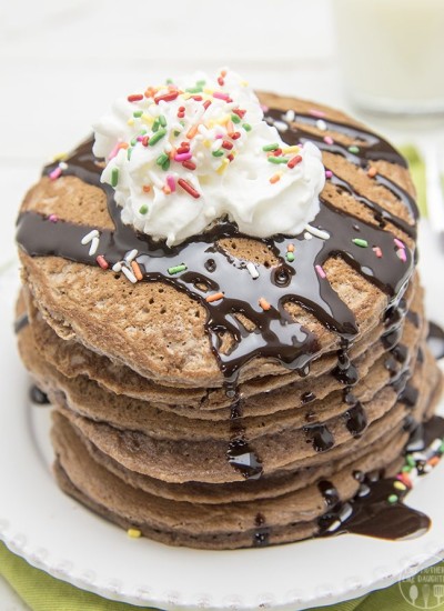 Above image of brownie batter pancakes with whipped cream and drizzle on top.