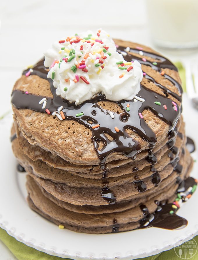 Above image of brownie batter pancakes with whipped cream and drizzle on top.