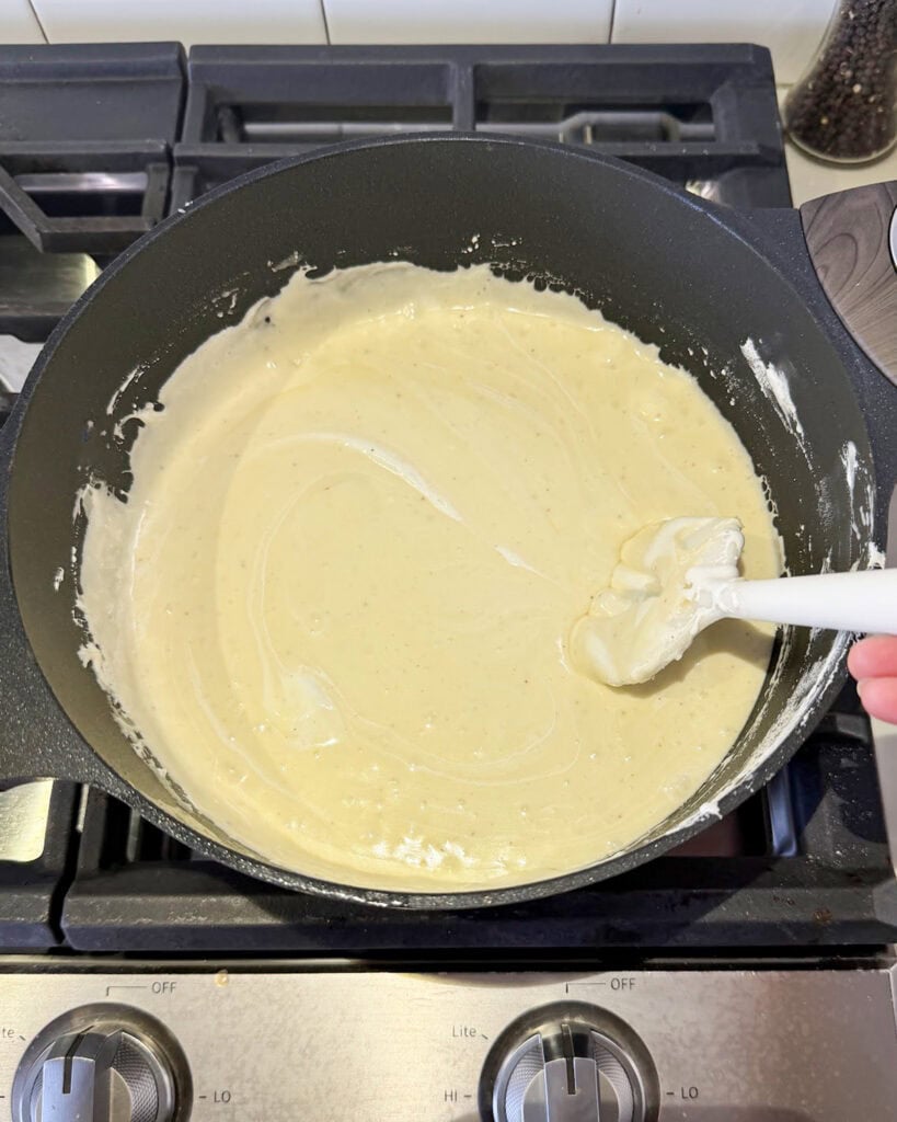 Eggnog fudge in a pot, with the marshmallow fluff still not fully mixed in.