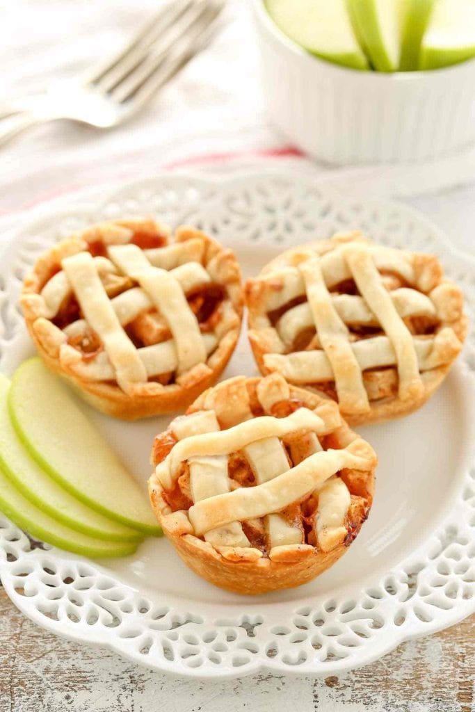 Three mini apple pies on a plate.