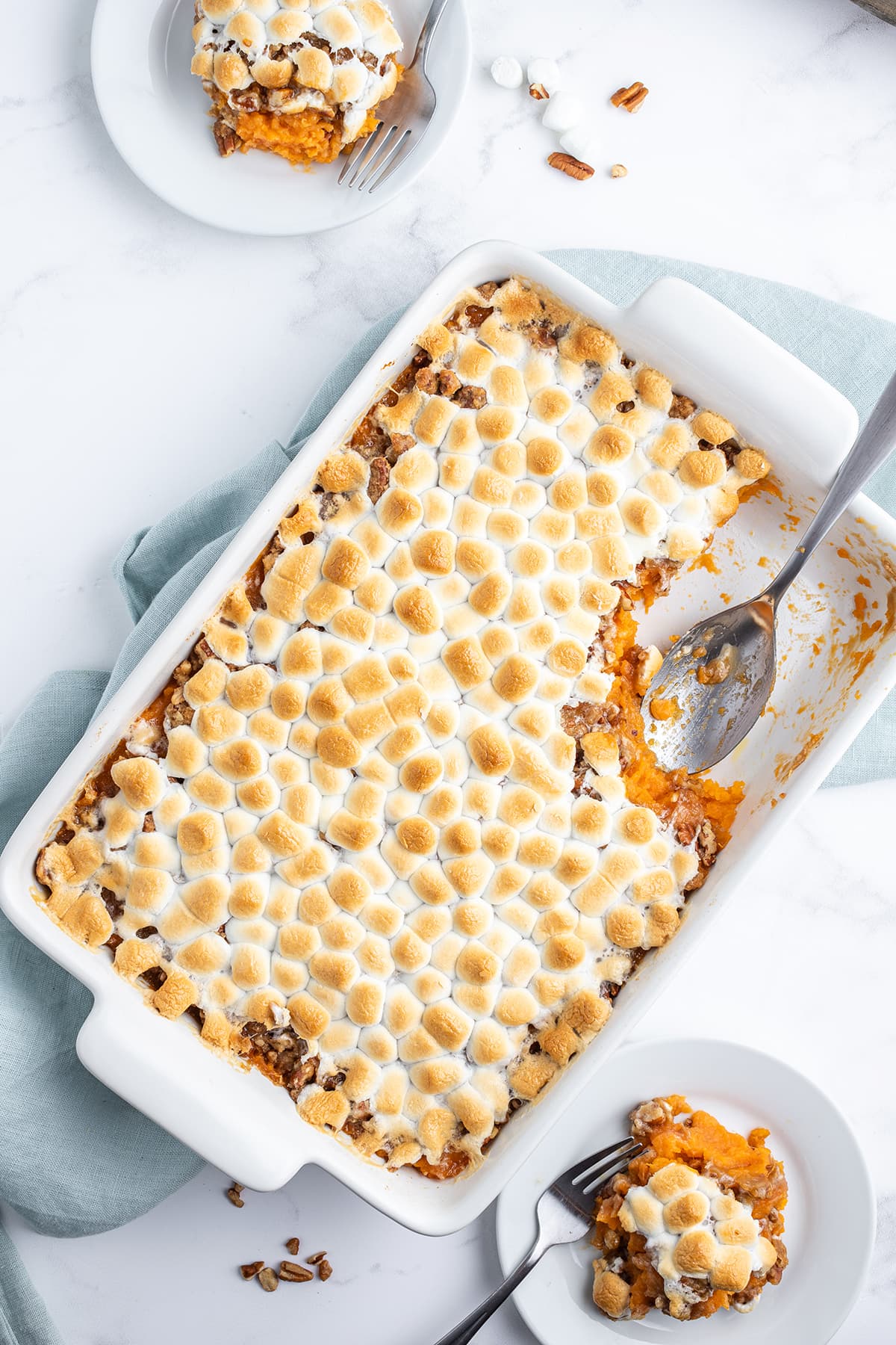 A pan of sweet potato casserole topped with toasted marshmallows.