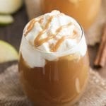 A glass of homemade caramel apple spice topped with whipped cream and caramel.