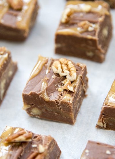 Rows of chocolate fudge with pecans and swirled with caramel on top.