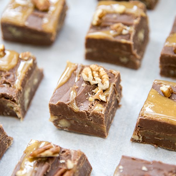 Rows of chocolate fudge with pecans and swirled with caramel on top.
