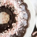 An overhead photo of a chocolate bundt cake topped with chopped peppermint pieces.