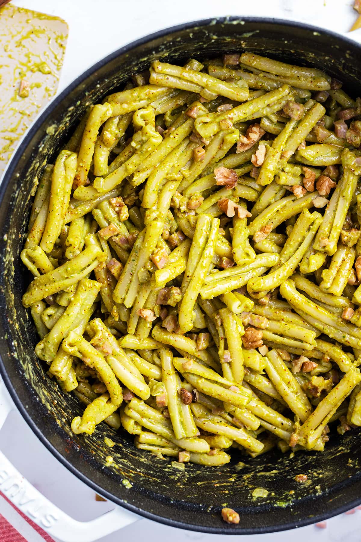 An overhead photo of a pot of Casarecce Pasta covered in pesto sauce.